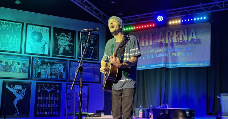 Musician with a guitar singing on stage at the Arena in Simi valley california